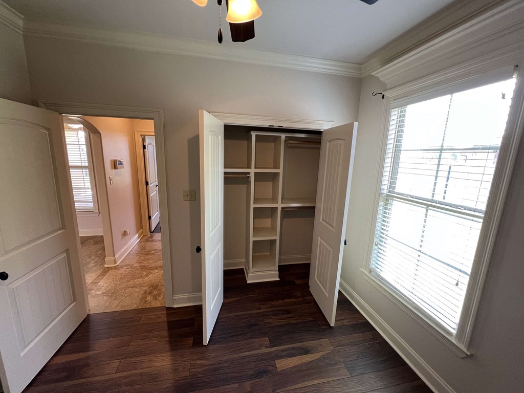 a bedroom with a closet and a large window