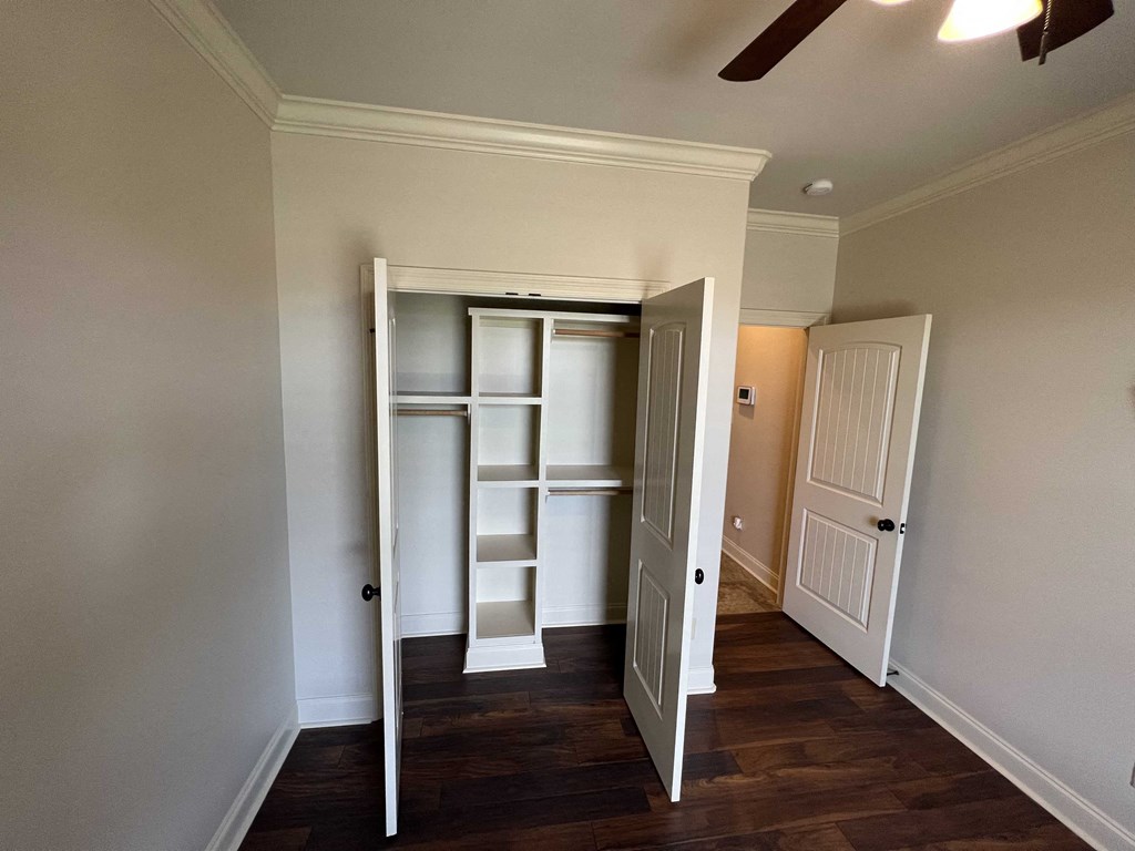a walk in closet with shelves and a door open
