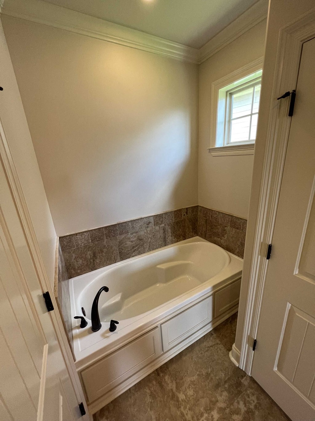 the master bathroom has a large tub and a window