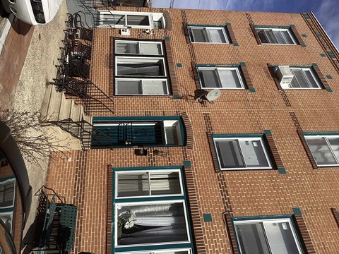 A building with a brick facade and green shutters.