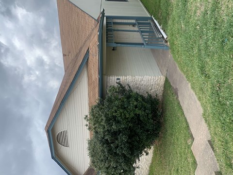 an overhead view of a building with a roof and a grass field