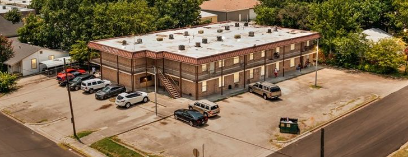 A parking lot with cars and a building in the background.