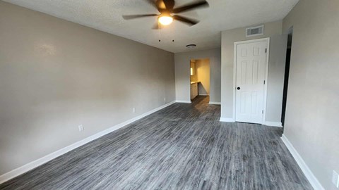 A room with a ceiling fan and a door.