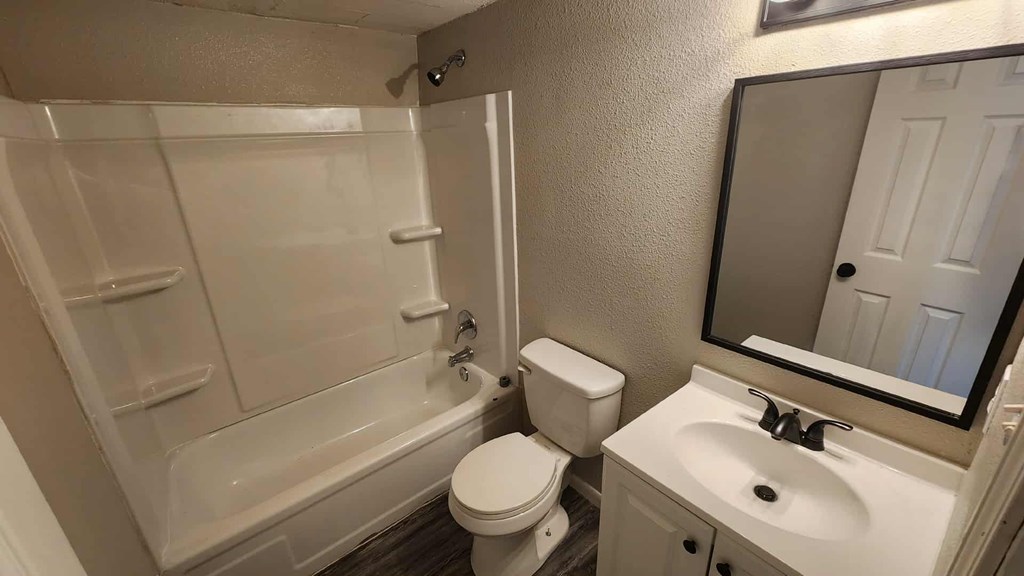 A white bathroom with a toilet, sink, and bathtub.