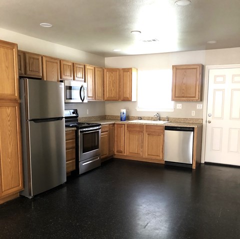 A kitchen with wooden cabinets and stainless steel appliances.