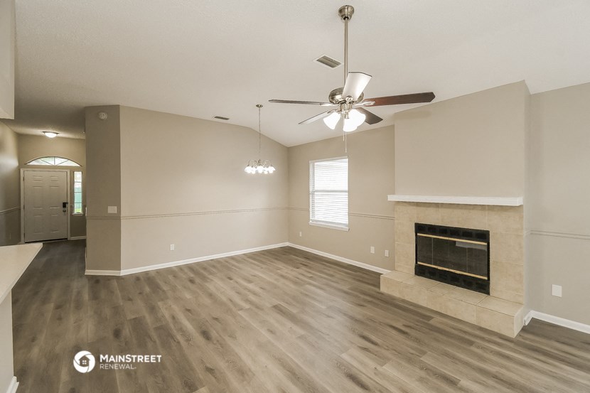 the living room with fireplace and ceiling fan