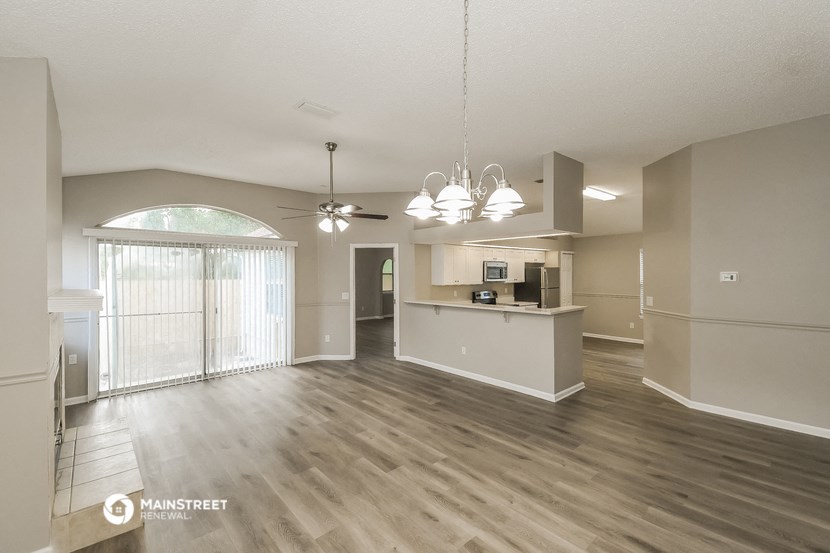 an open living room and kitchen with a sliding glass door