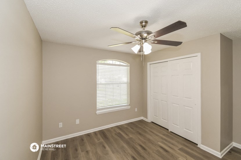 the bedroom of our studio apartment atrium with ceiling fan and door