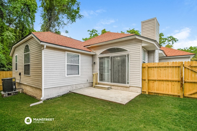 a backyard with a house and a wooden fence