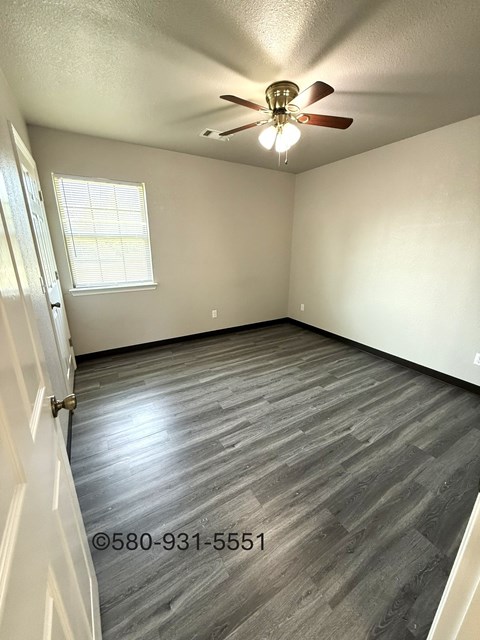 A room with a ceiling fan and a window.