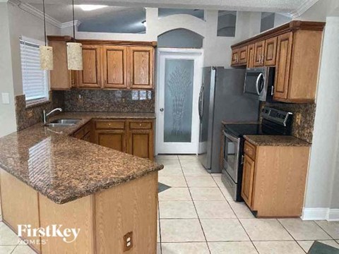 A kitchen with granite countertops and wooden cabinets.
