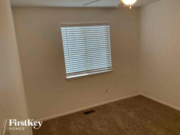 an empty room with a window and a carpet