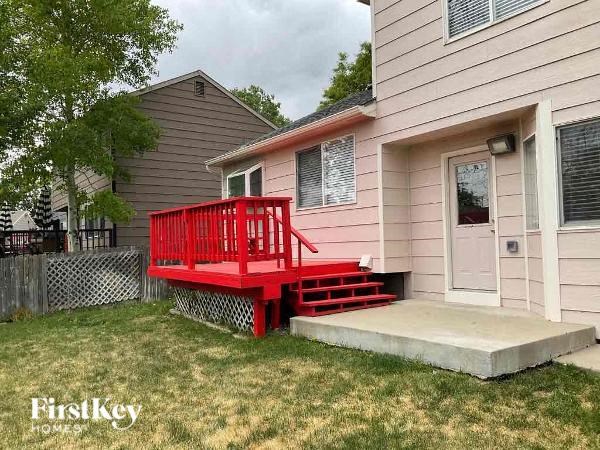 a red bench in front of a pink house