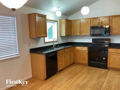 a kitchen with black appliances and wooden cabinets