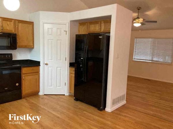 a kitchen with a black refrigerator and a door