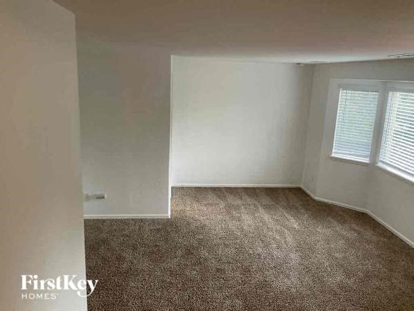 an empty room with a carpeted floor and a window