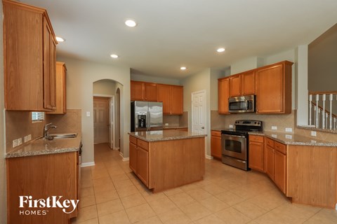 A kitchen with wooden cabinets and a refrigerator.