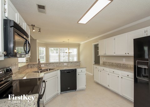 a large kitchen with white cabinets and granite counter tops