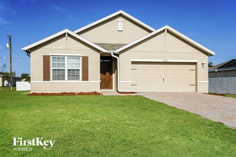 a beige house with a lawn in front of it