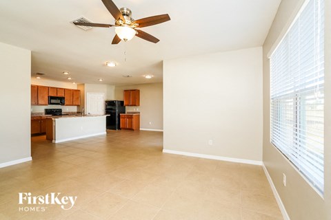 an empty kitchen and living room with a ceiling fan