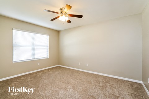 a bedroom with a ceiling fan and a window