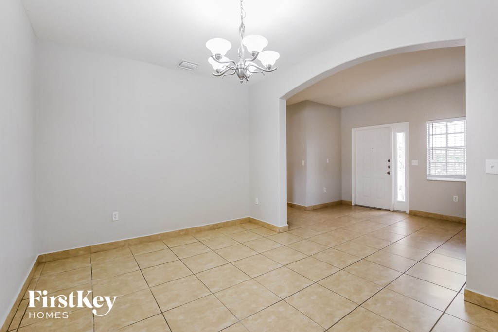 the living room and dining room are spacious and lighted by a chandelier