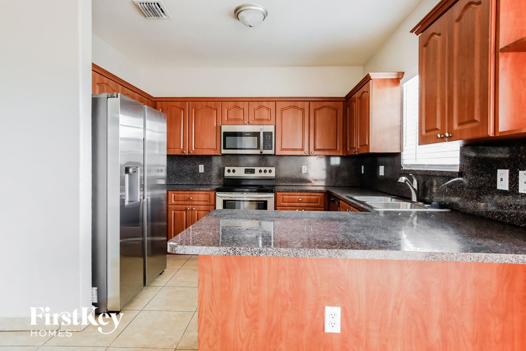 a kitchen with wooden cabinets and stainless steel appliances and granite counter tops