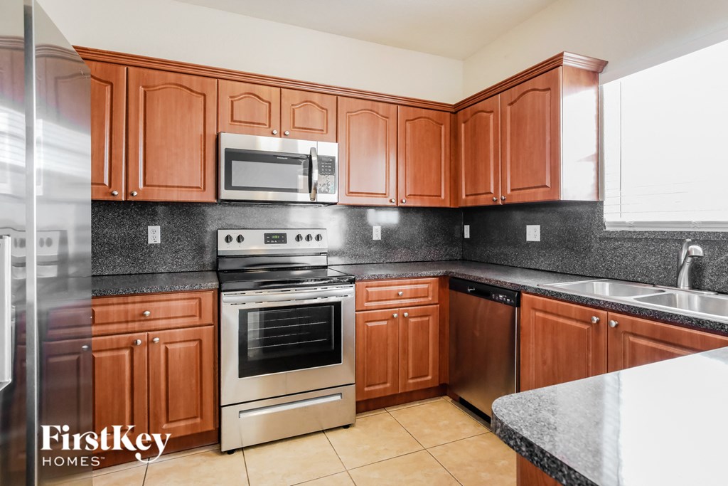 a kitchen with wooden cabinets and stainless steel appliances