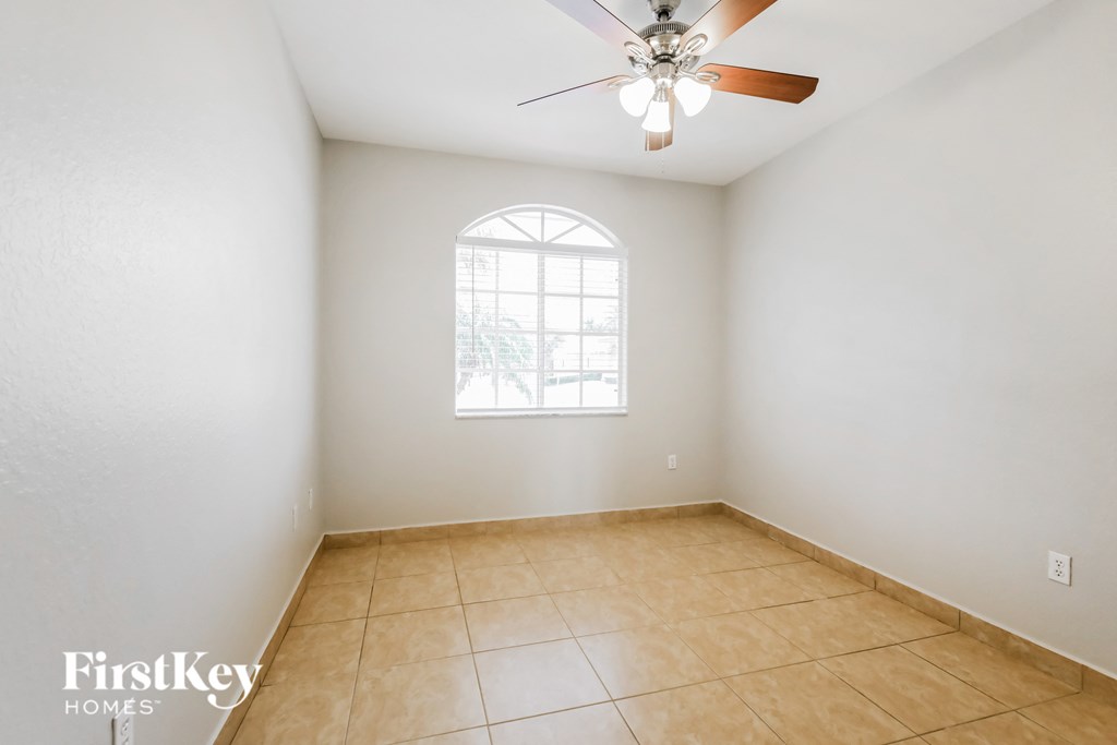a empty room with a ceiling fan and a window