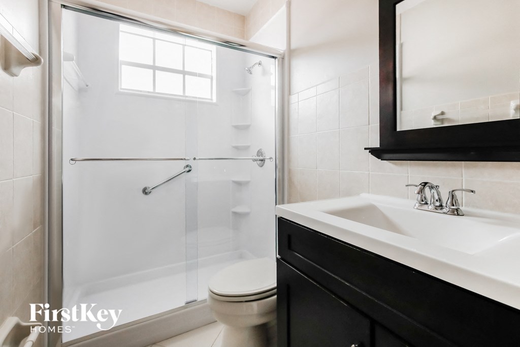 a white bathroom with a shower and a sink and a toilet