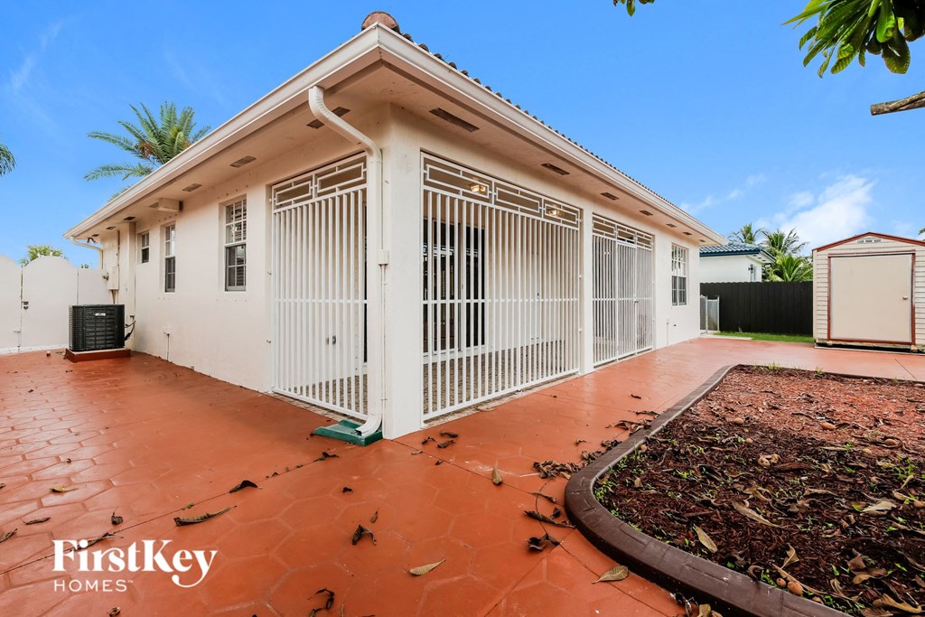 a white house with white gates and a driveway