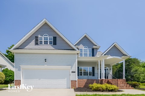 A two-story house with a garage and a covered porch.
