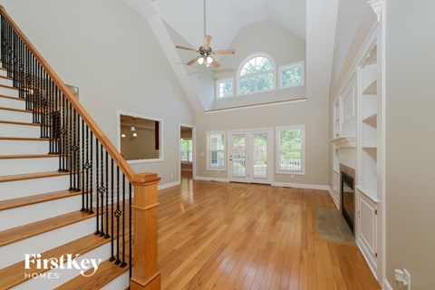 A spacious home interior with a staircase and a fireplace.