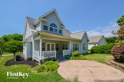 A house with a blue and white exterior and a large front porch.