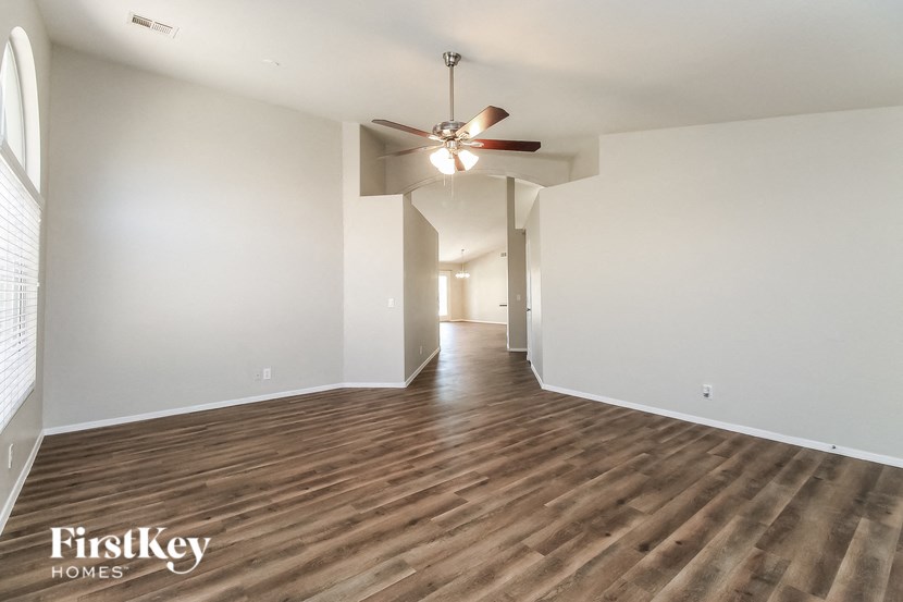 a living room with white walls and a ceiling fan