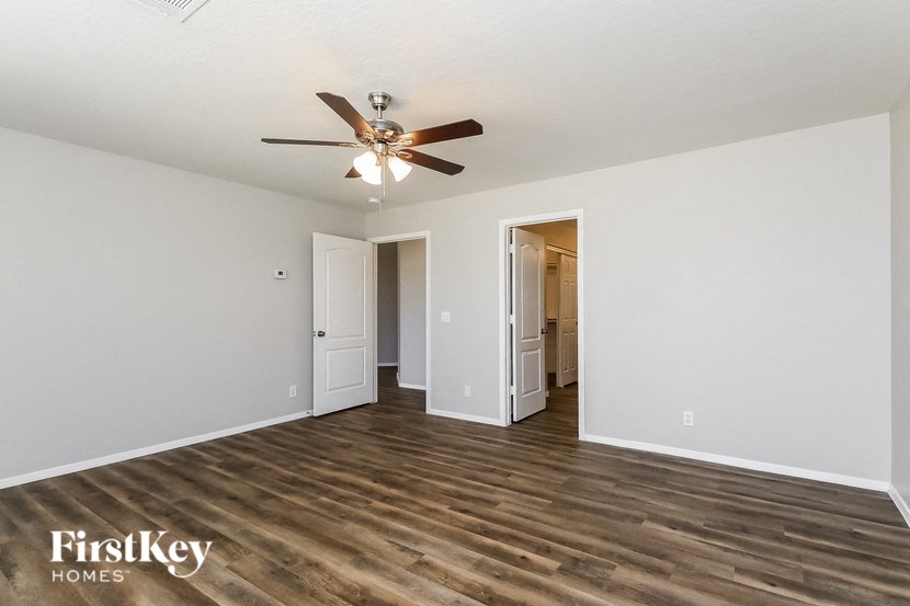 a living room with white walls and a ceiling fan