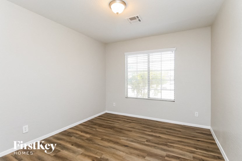the spacious living room with wood flooring and a window