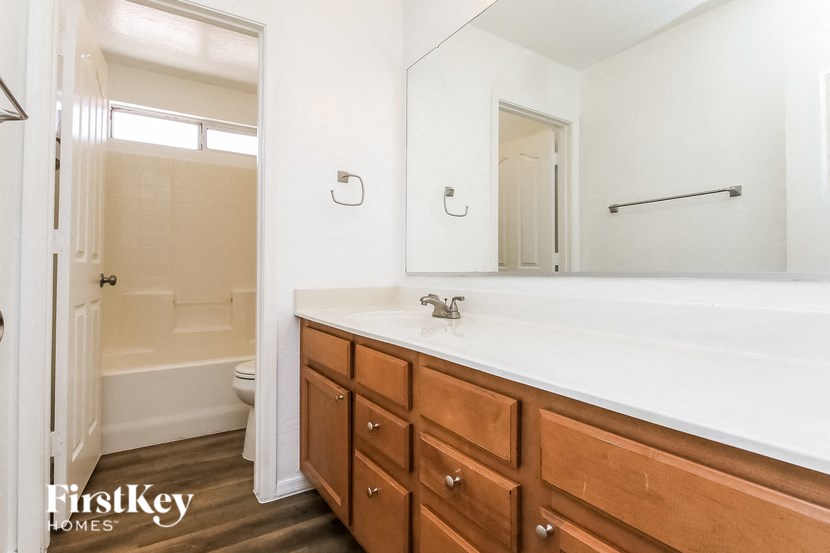 a bathroom with a large mirror and a sink and a toilet