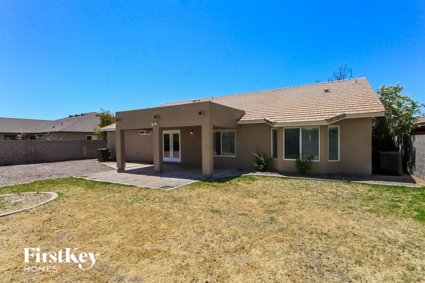 a beige house with a yard and a driveway