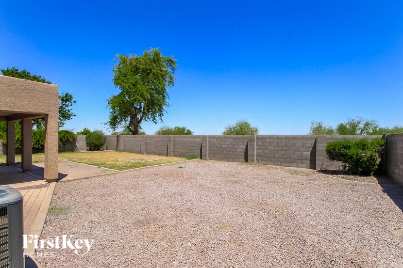 a backyard with a fence and a blue sky