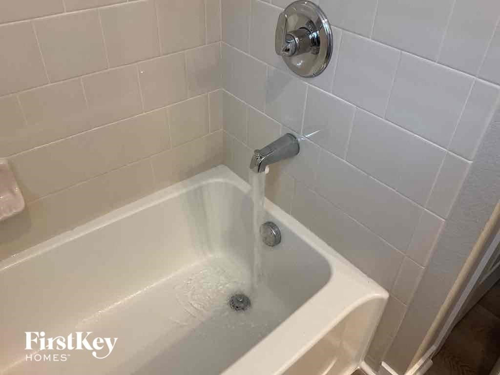 a bath tub with water being poured into it in a bathroom