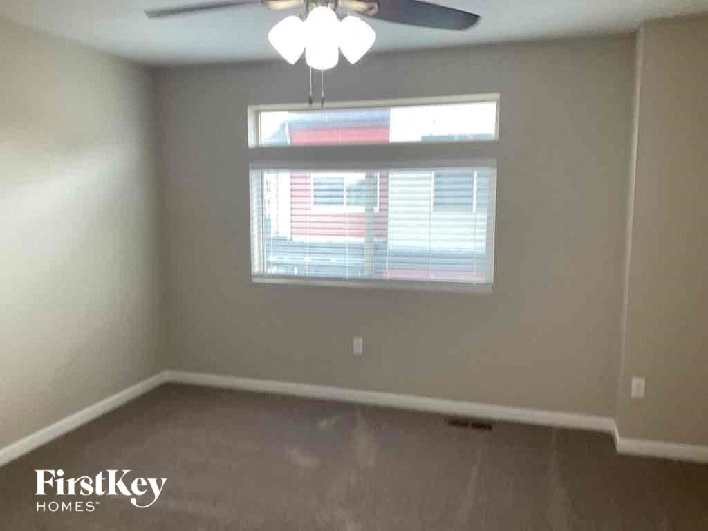 an empty room with a window and a ceiling fan