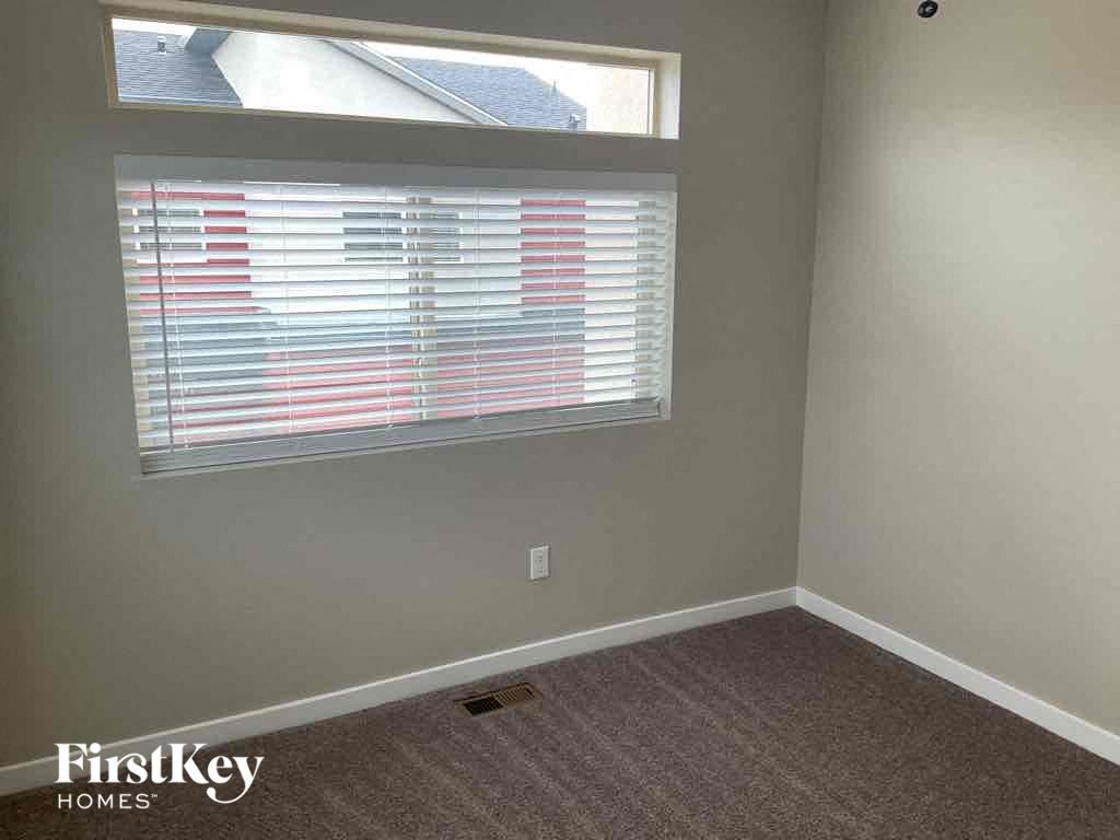 an empty room with a window and a carpet