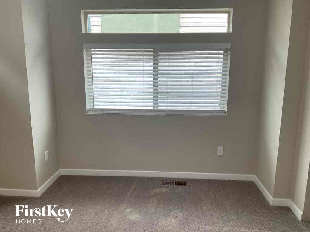 a small room with a window and a carpet