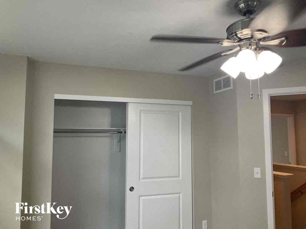 a bedroom with a ceiling fan and a closet