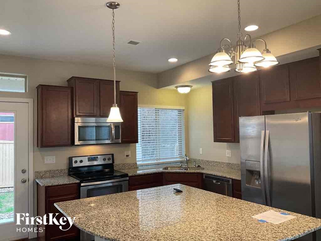 an updated kitchen with granite counter tops and stainless steel appliances