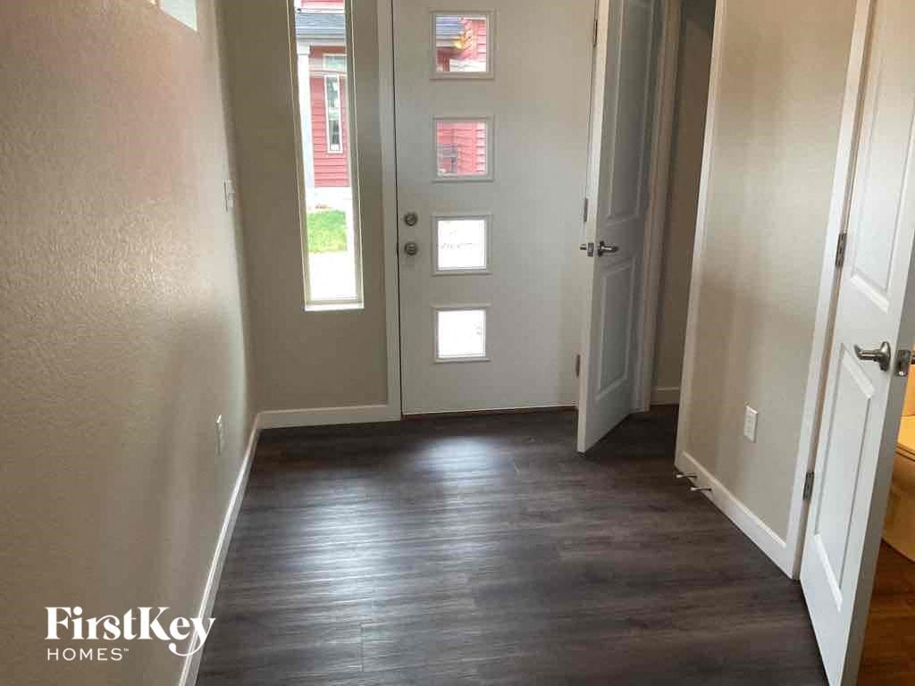 a hallway with a hard wood floor and white doors