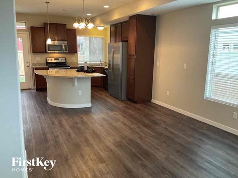a kitchen with wooden floors and a stainless steel refrigerator