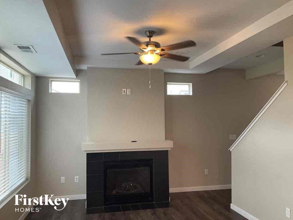 a living room with a ceiling fan and a fireplace