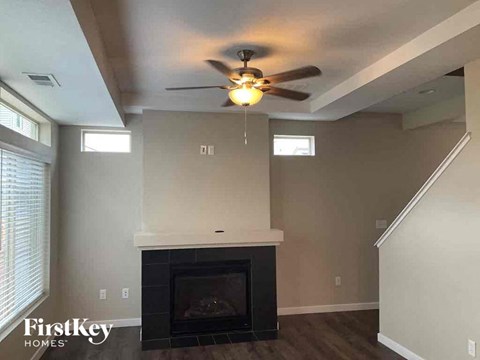 a living room with a ceiling fan and a fireplace